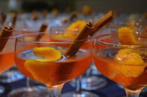 orange cocktails with cinnamon stick and orange slice